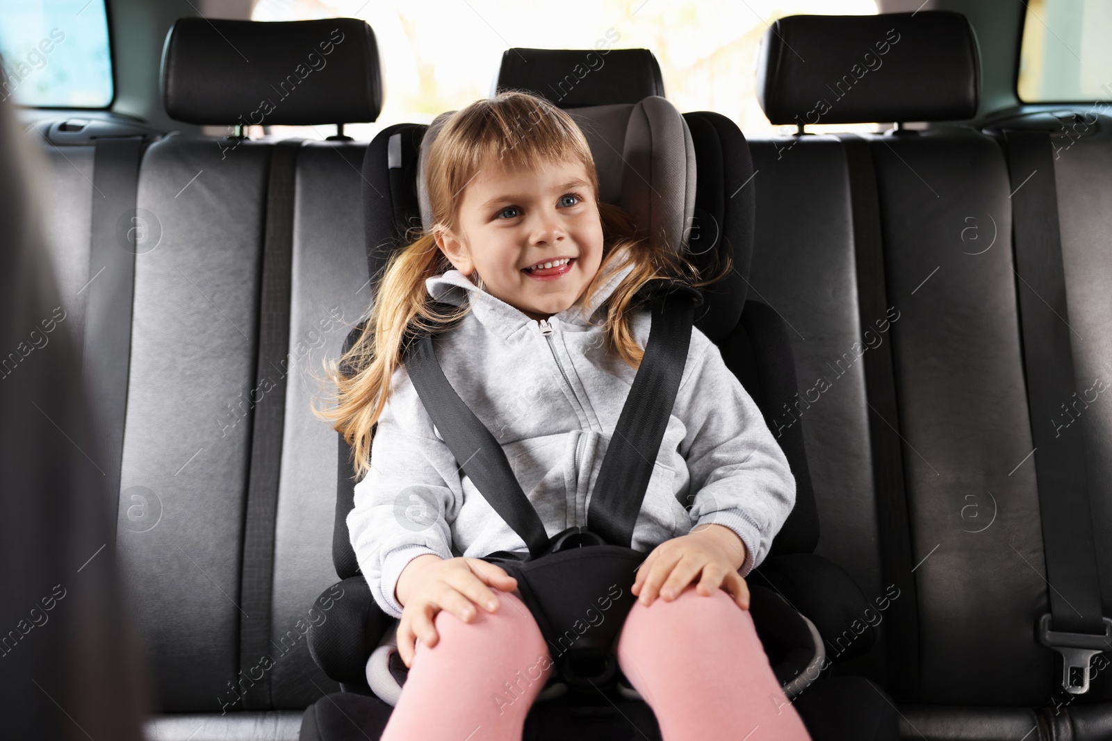 Little girl sitting in child safety seat inside car Photo of Little girl sitting in child safety seat inside car
