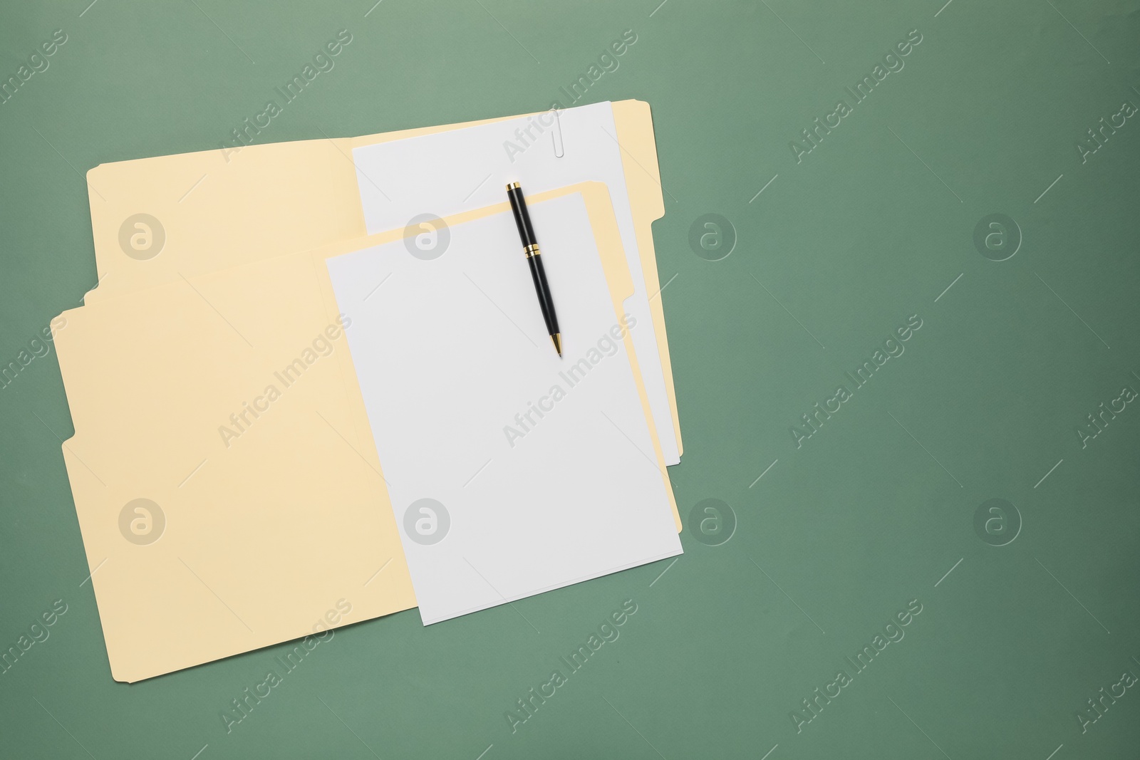 Paper file folder with blank sheets and pen on green background, top view. Space for text Photo of Paper file folder with blank sheets and pen on green background, top view. Space for text