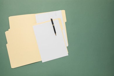 Photo of Paper file folder with blank sheets and pen on green background, top view. Space for text