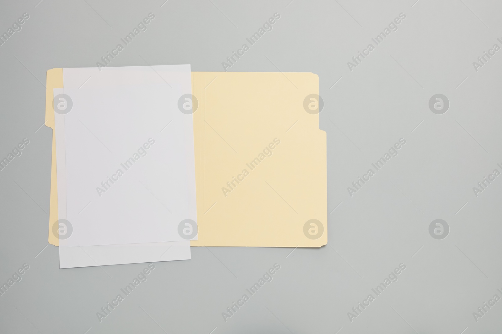 Paper file folder with blank sheets on gray background, top view. Space for text Photo of Paper file folder with blank sheets on gray background, top view. Space for text