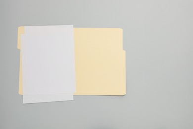 Photo of Paper file folder with blank sheets on gray background, top view. Space for text