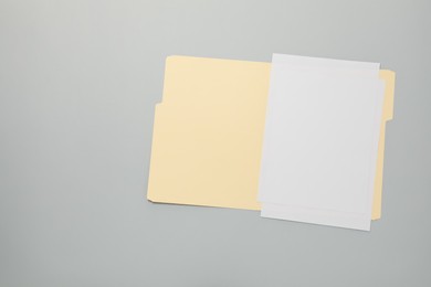 Photo of Paper file folder with blank sheets on gray background, top view. Space for text