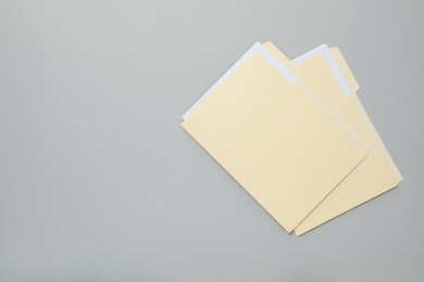 Photo of File folders with papers on gray background, top view. Space for text