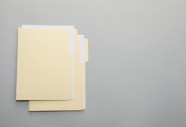 Photo of File folders with papers on gray background, top view. Space for text