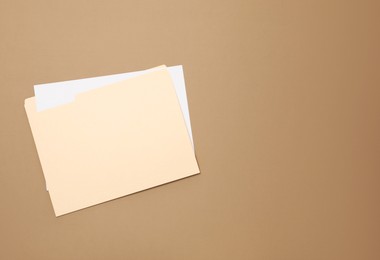 Photo of Paper file folder on brown background, top view. Space for text