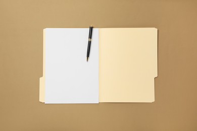Photo of Paper file folder with blank sheet and pen on light brown background, top view
