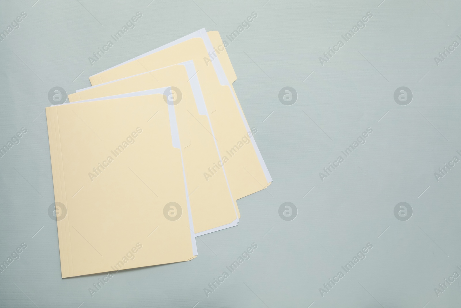 File folders with papers on gray background, top view. Space for text Photo of File folders with papers on gray background, top view. Space for text