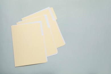 Photo of File folders with papers on gray background, top view. Space for text