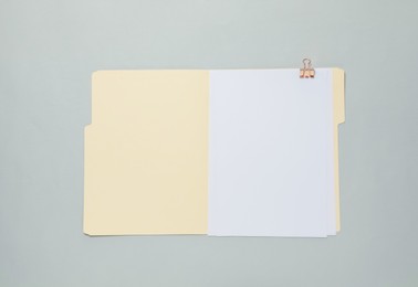 Photo of Paper file folder with blank sheet on gray background, top view
