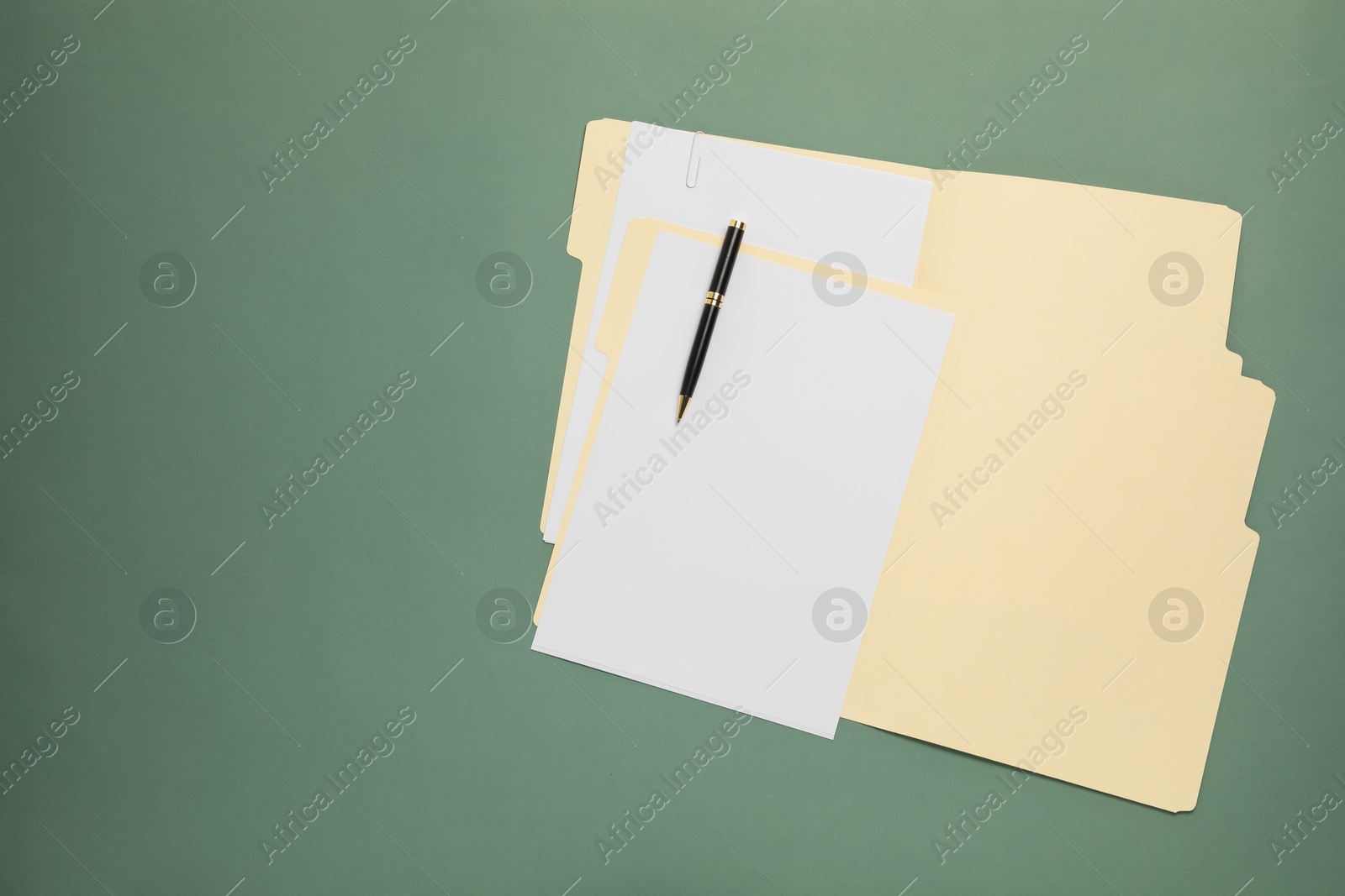 Paper file folders with blank sheets and pen on green background, top view. Space for text Photo of Paper file folders with blank sheets and pen on green background, top view. Space for text