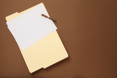 Photo of Paper file folder with blank sheet on brown background, top view. Space for text