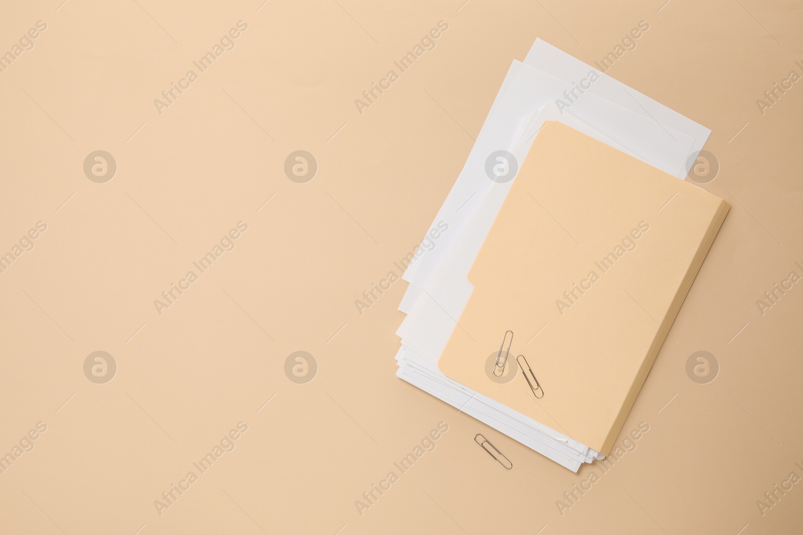 File folder with sheets and paper clips on beige background, flat lay. Space for text Photo of File folder with sheets and paper clips on beige background, flat lay. Space for text