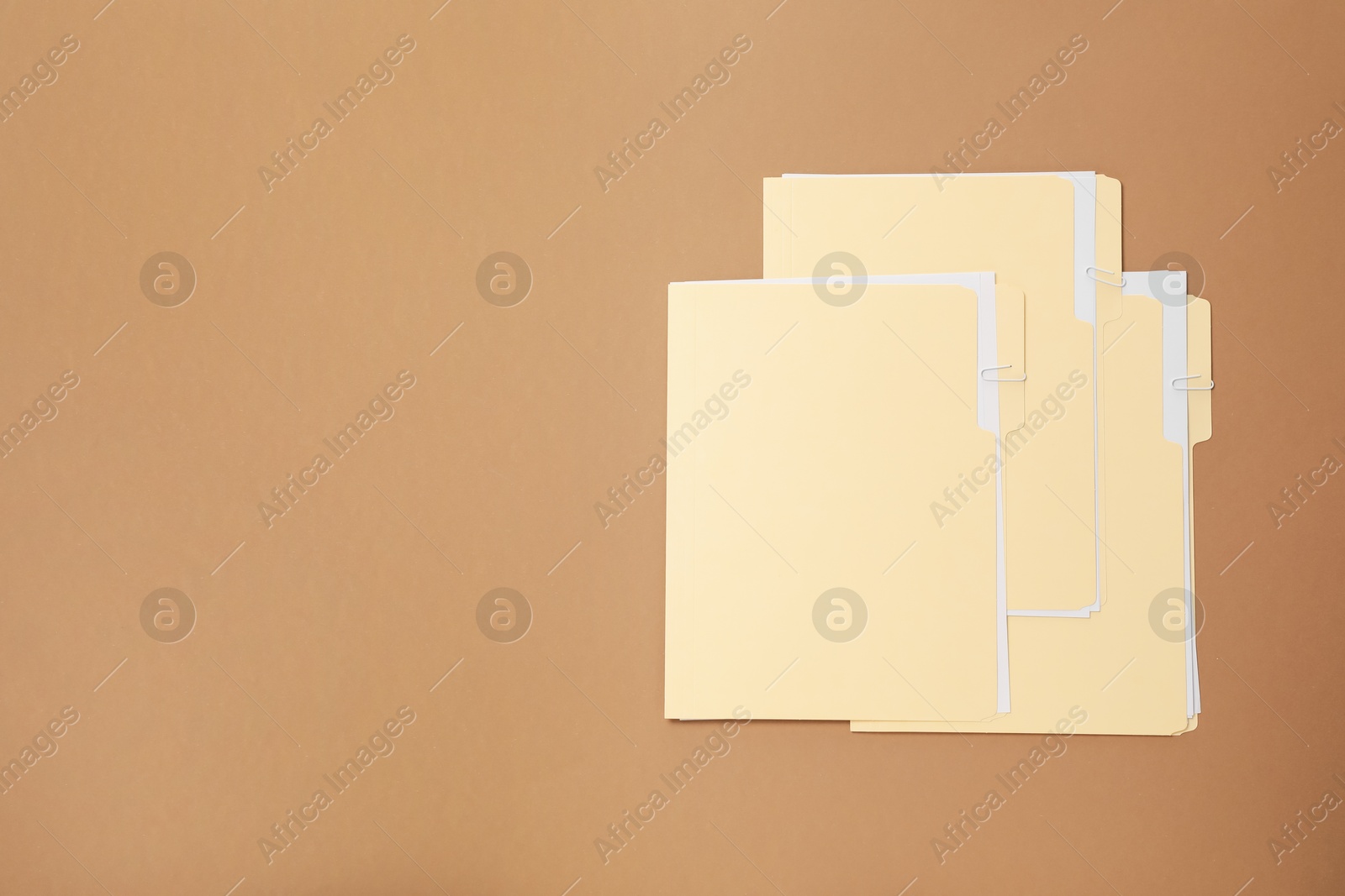 File folders with papers on light brown background, flat lay. Space for text Photo of File folders with papers on light brown background, flat lay. Space for text