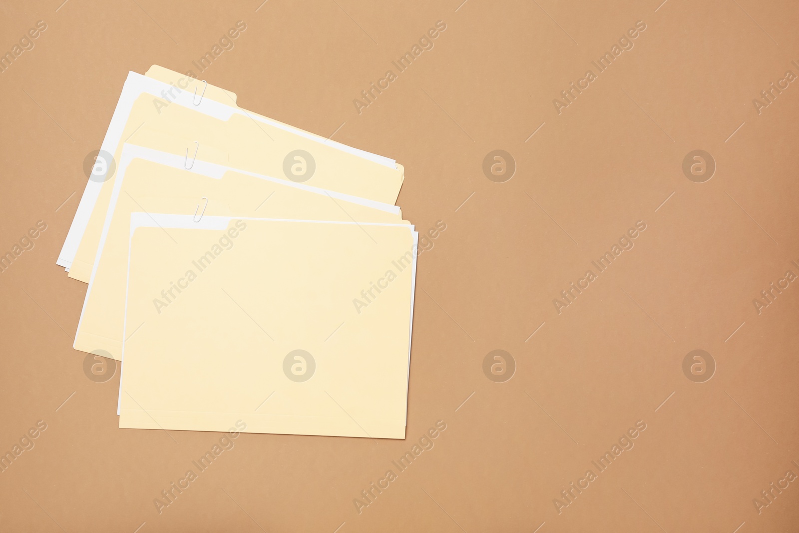 File folders with papers on light brown background, flat lay. Space for text Photo of File folders with papers on light brown background, flat lay. Space for text