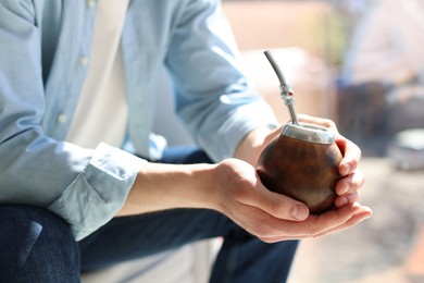 Photo of Man with traditional yerba mate tea at home, closeup