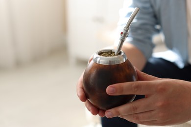 Photo of Man with traditional yerba mate tea at home, closeup. Space for text