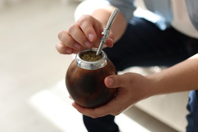 Photo of Man with traditional yerba mate tea at home, closeup