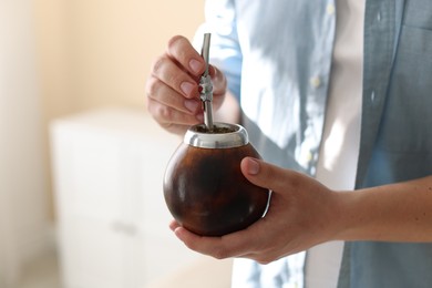 Photo of Man with traditional yerba mate tea at home, closeup