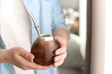 Photo of Man with traditional yerba mate tea at home, closeup