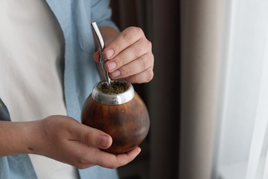 Photo of Man with traditional yerba mate tea at home, closeup. Space for text