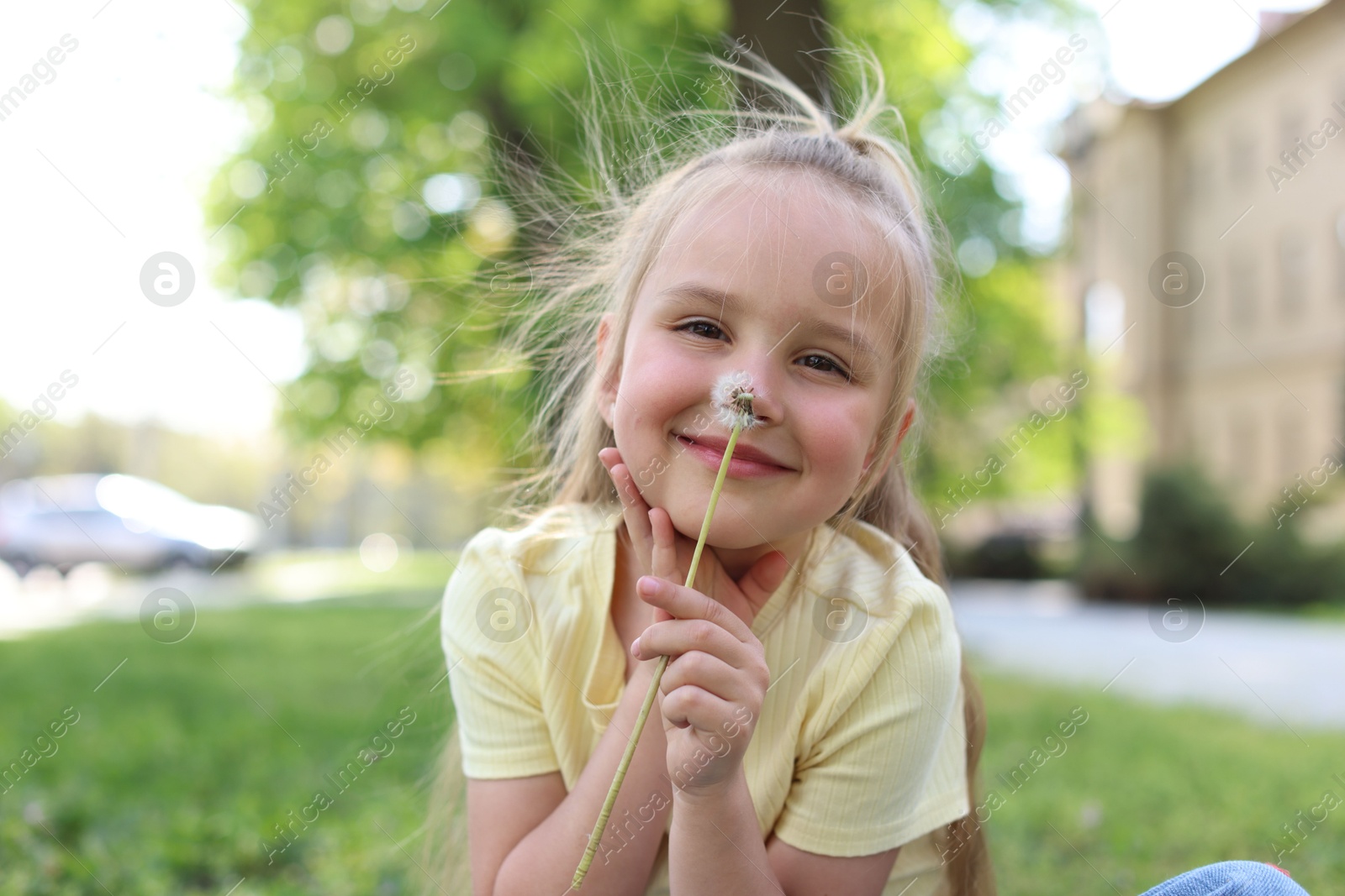 Cute little girl with beautiful dandelion outdoors Photo of Cute little girl with beautiful dandelion outdoors