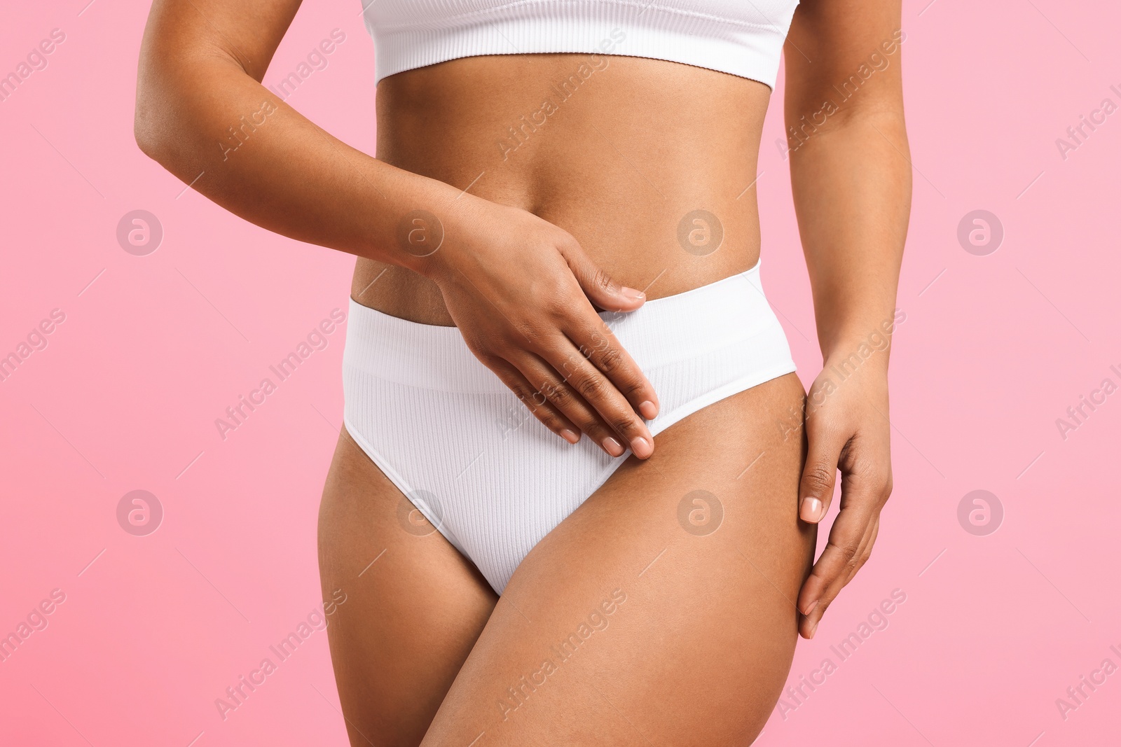 Woman in white underwear with smooth skin after epilation procedure on pink background, closeup Photo of Woman in white underwear with smooth skin after epilation procedure on pink background, closeup