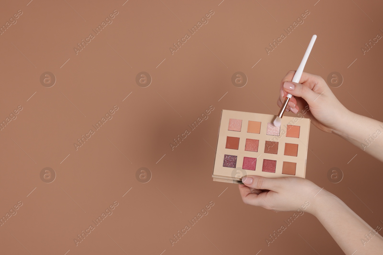 Woman with eyeshadow palette and brush on beige background, closeup. Space for text Photo of Woman with eyeshadow palette and brush on beige background, closeup. Space for text