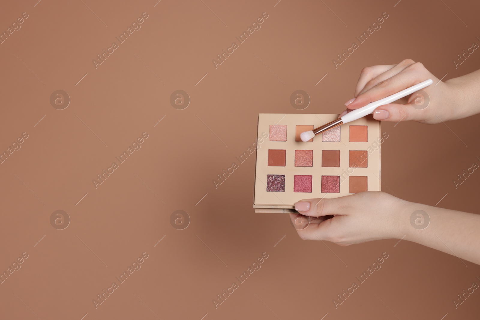 Woman with eyeshadow palette and brush on beige background, closeup. Space for text Photo of Woman with eyeshadow palette and brush on beige background, closeup. Space for text