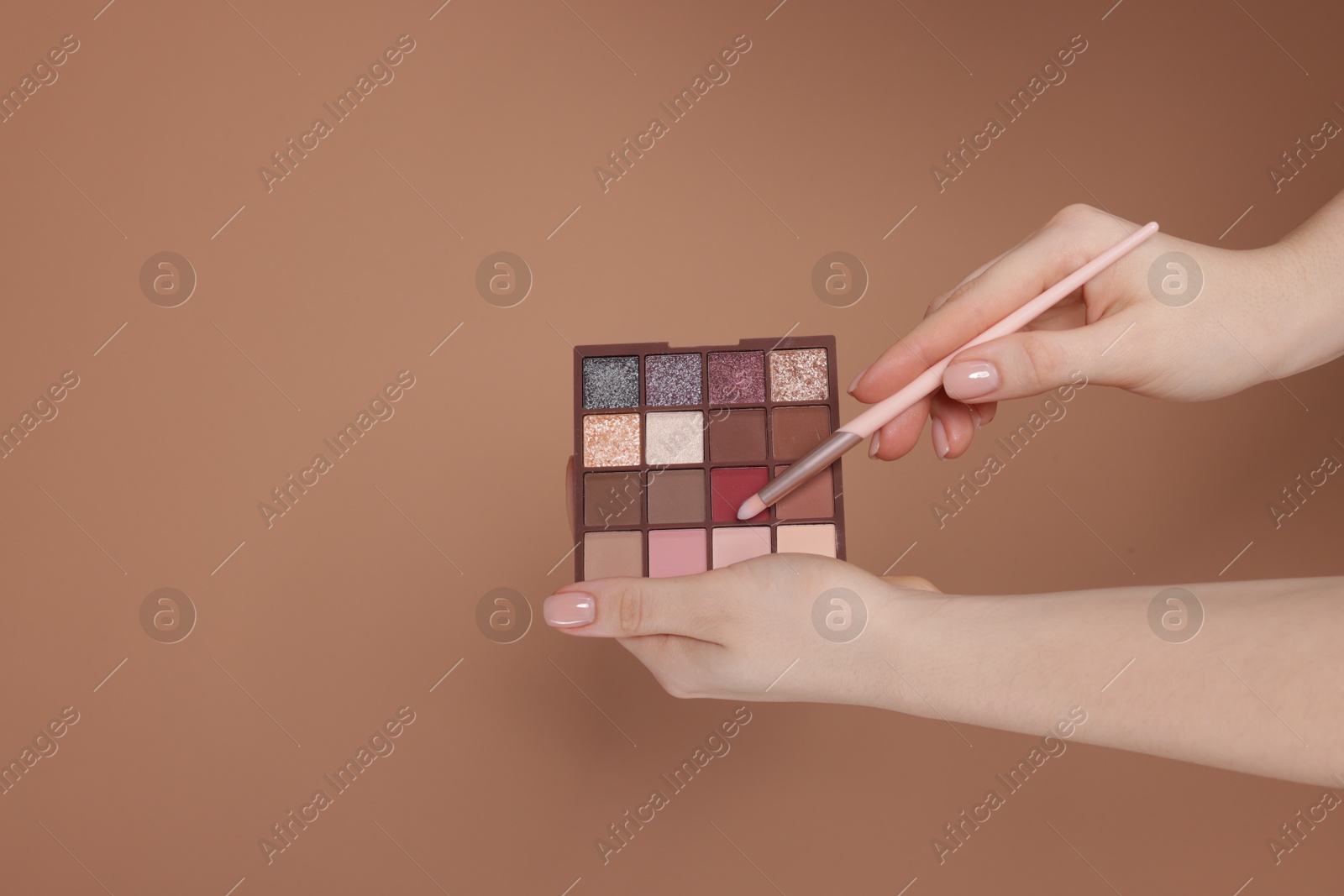 Woman with eyeshadow palette and brush on beige background, closeup. Space for text Photo of Woman with eyeshadow palette and brush on beige background, closeup. Space for text