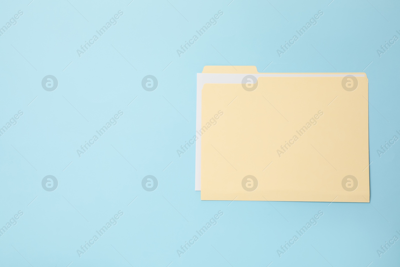 Paper file folder on light blue background, top view. Space for text Photo of Paper file folder on light blue background, top view. Space for text
