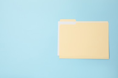 Photo of Paper file folder on light blue background, top view. Space for text