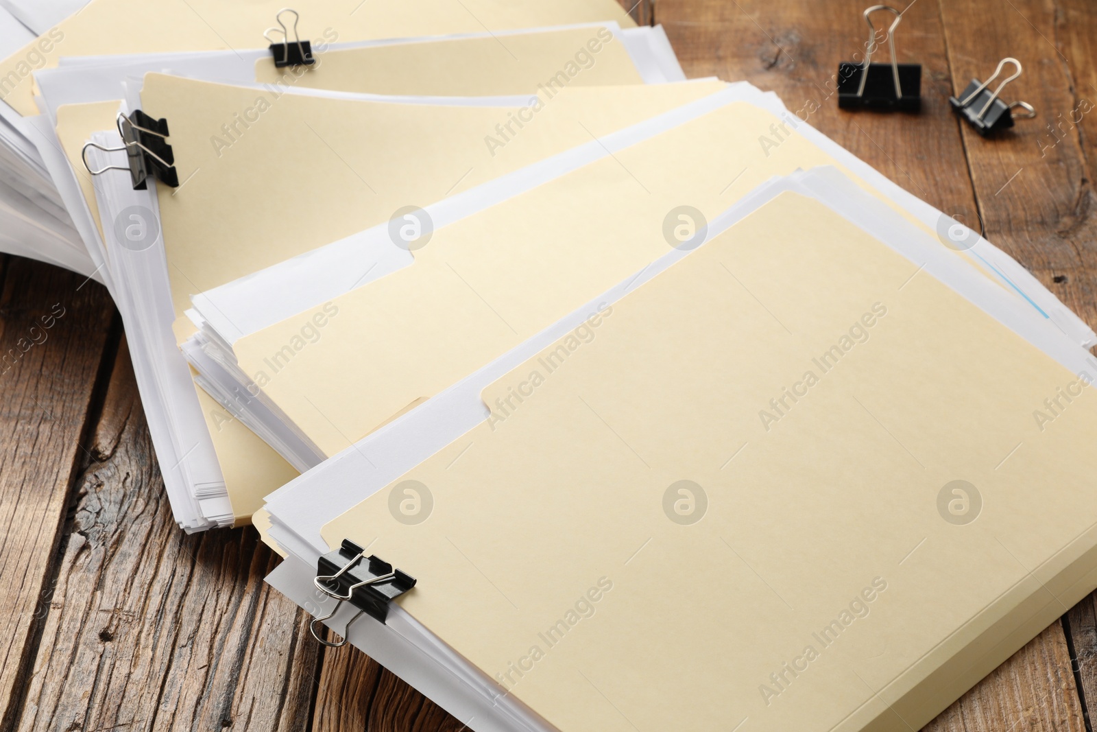 File folders with papers and binder clips on wooden table, closeup Photo of File folders with papers and binder clips on wooden table, closeup