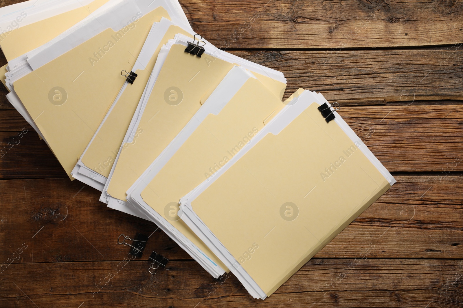 File folders with papers and binder clips on wooden table, flat lay Photo of File folders with papers and binder clips on wooden table, flat lay