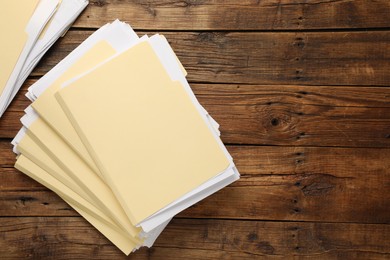 Photo of File folders with papers on wooden table, flat lay. Space for text