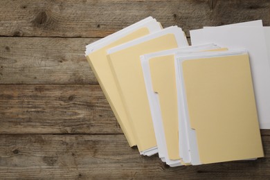 Photo of File folders with papers on wooden table, flat lay. Space for text