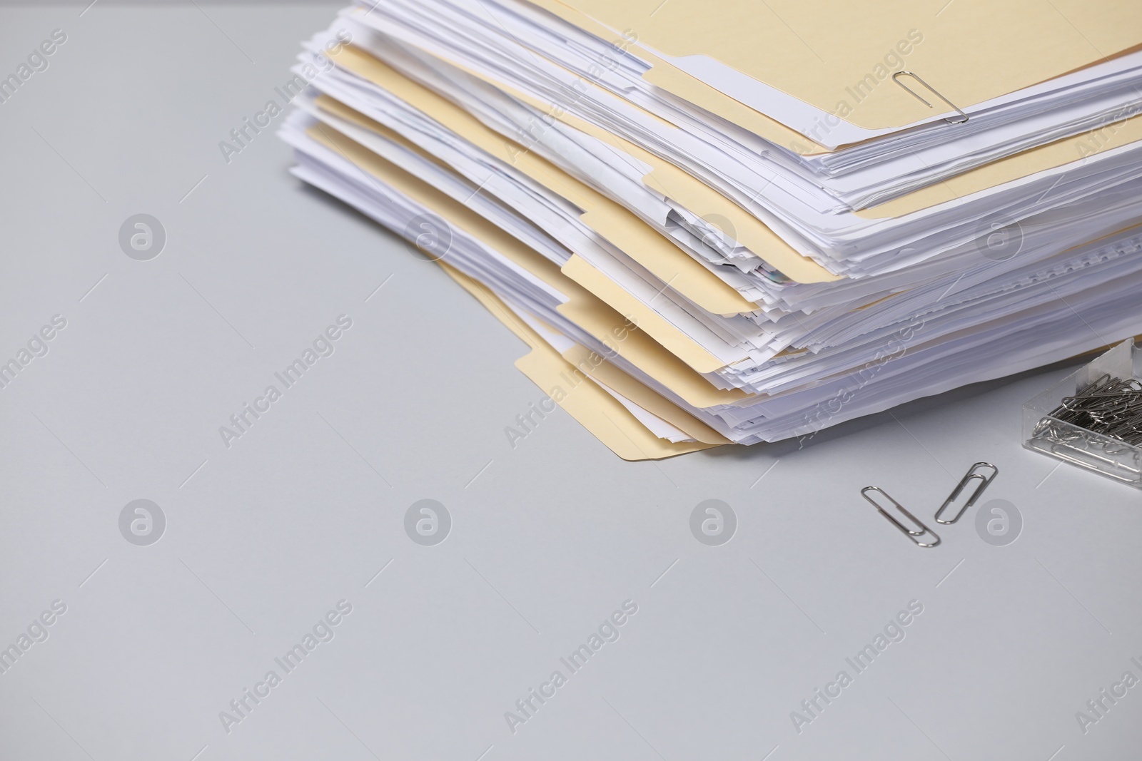 File folders with documents and paper clips on gray background, closeup. Space for text Photo of File folders with documents and paper clips on gray background, closeup. Space for text