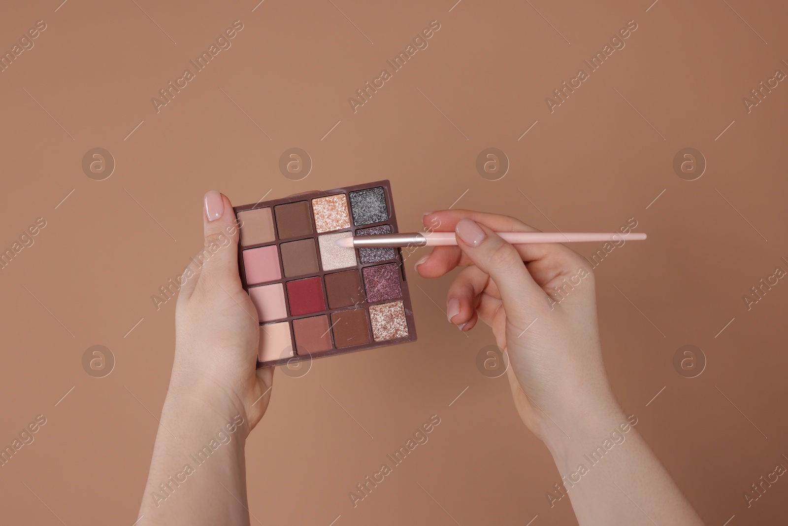 Woman with eyeshadow palette and brush on beige background, closeup Photo of Woman with eyeshadow palette and brush on beige background, closeup
