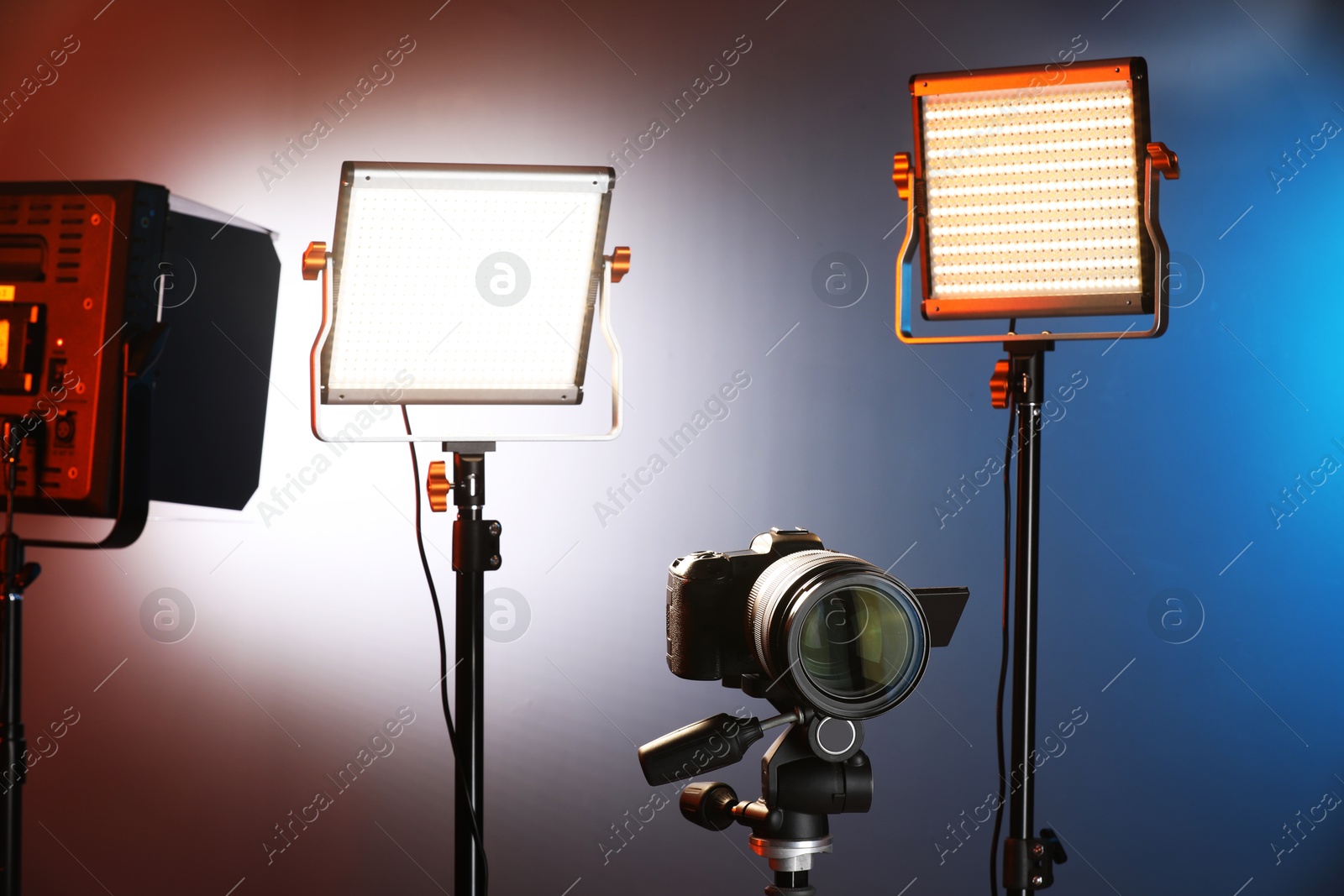 Professional lighting equipment and camera on color background Photo of Professional lighting equipment and camera on color background