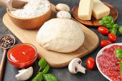 Photo of Making pizza. Different ingredients on gray textured table, closeup