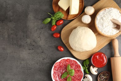 Photo of Making pizza. Different ingredients on gray textured table, flat lay. Space for text