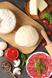 Photo of Making pizza. Different ingredients on gray textured table, flat lay