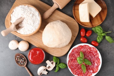 Photo of Making pizza. Different ingredients on gray textured table, flat lay
