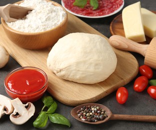 Photo of Making pizza. Different ingredients on gray textured table, closeup