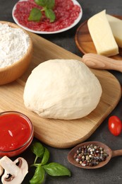 Photo of Making pizza. Different ingredients on gray textured table, closeup