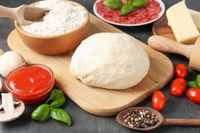 Photo of Making pizza. Different ingredients on gray textured table, closeup