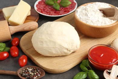 Photo of Making pizza. Different ingredients on gray textured table, closeup