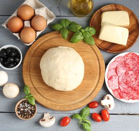Photo of Making pizza. Different ingredients on gray wooden table, flat lay