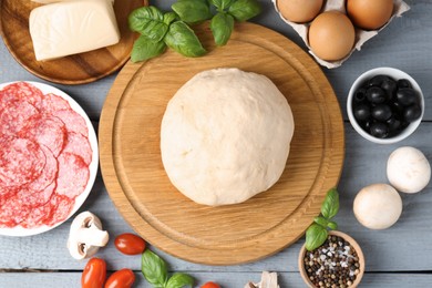 Photo of Making pizza. Different ingredients on gray wooden table, flat lay