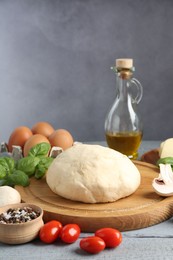 Photo of Making pizza. Different ingredients on gray wooden table