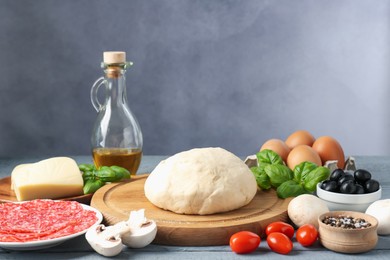 Photo of Making pizza. Different ingredients on gray wooden table